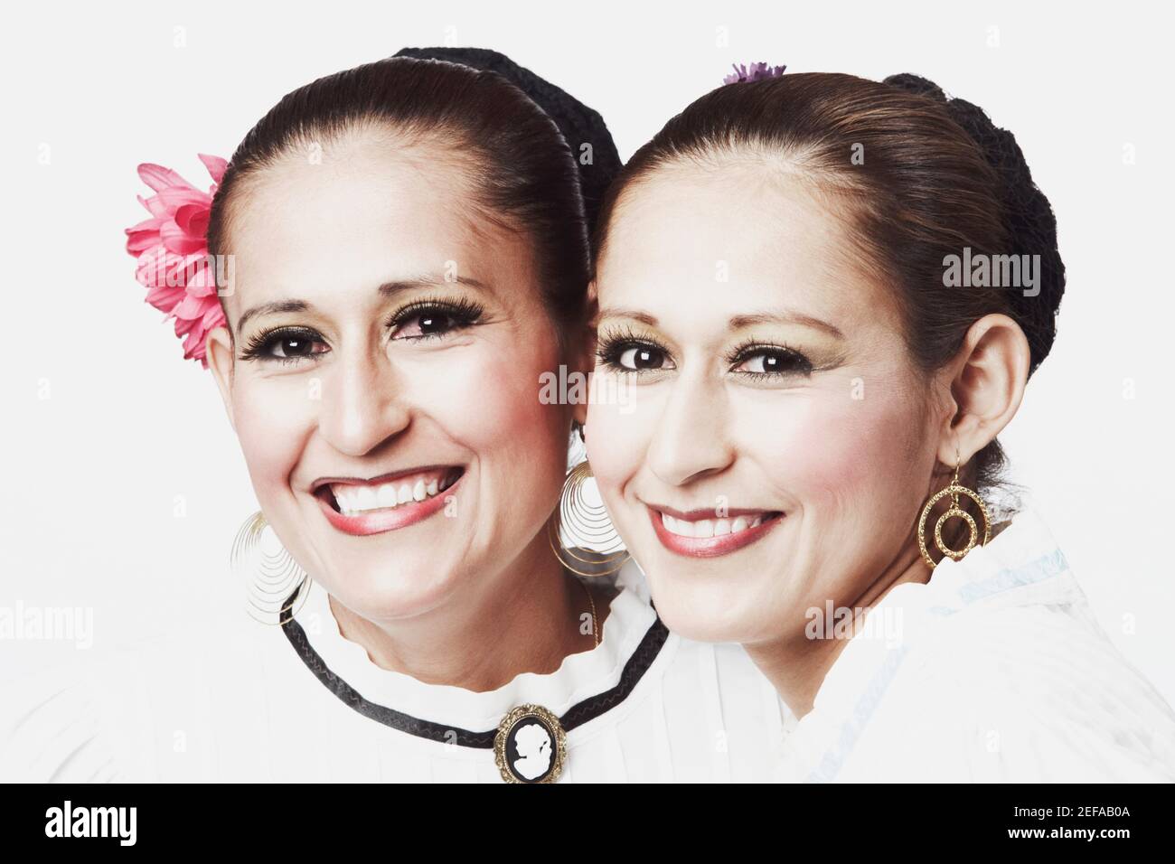 Portrait of two young women posing and smiling Stock Photo - Alamy