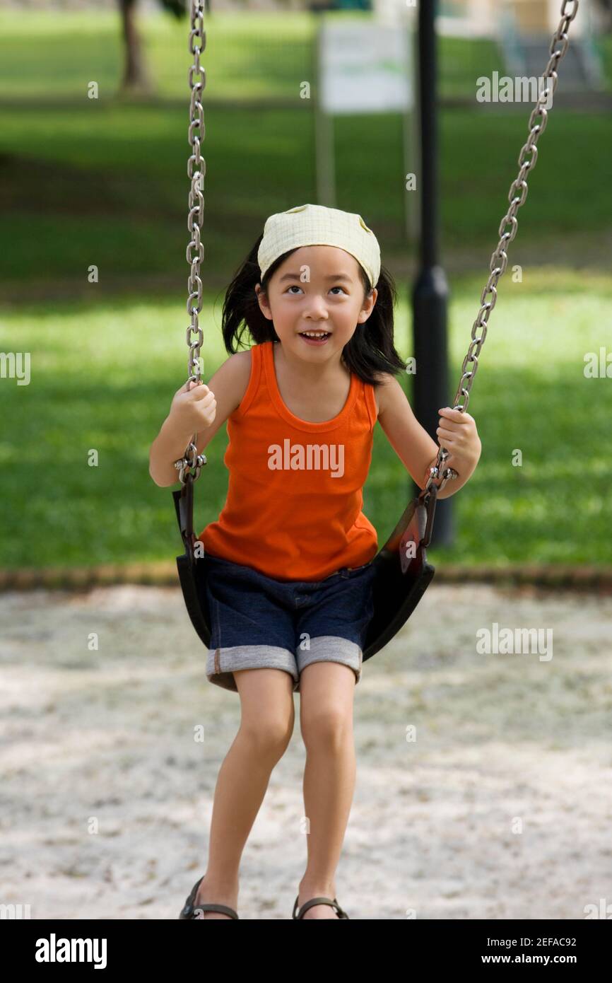 Girl swinging on a chain swing ride and smiling Stock Photo Alamy