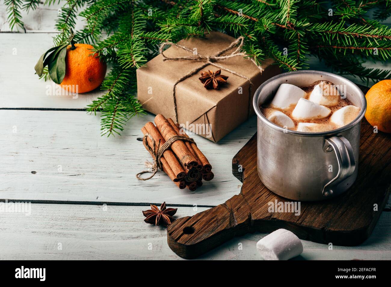 Rustic mug of hot chocolate with marshmallows on cutting board Stock Photo