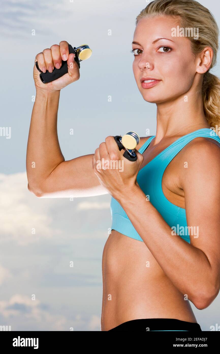 Portrait of a young woman squeezing hand grips Stock Photo