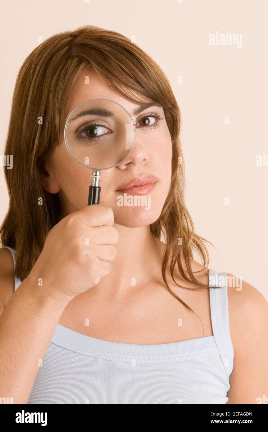 Portrait of a young woman looking through a magnifying glass Stock ...