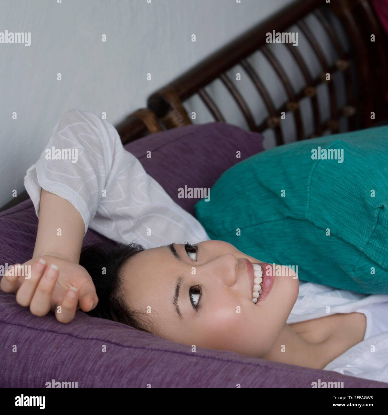 Young woman lying on a couch and smiling Stock Photo - Alamy