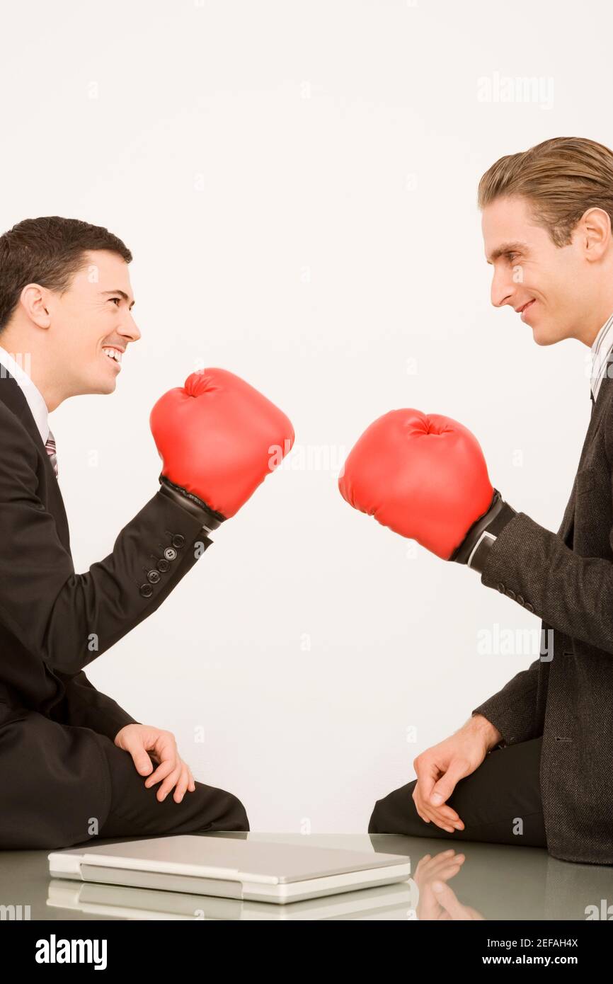Side profile of two businessmen wearing boxing gloves Stock Photo - Alamy