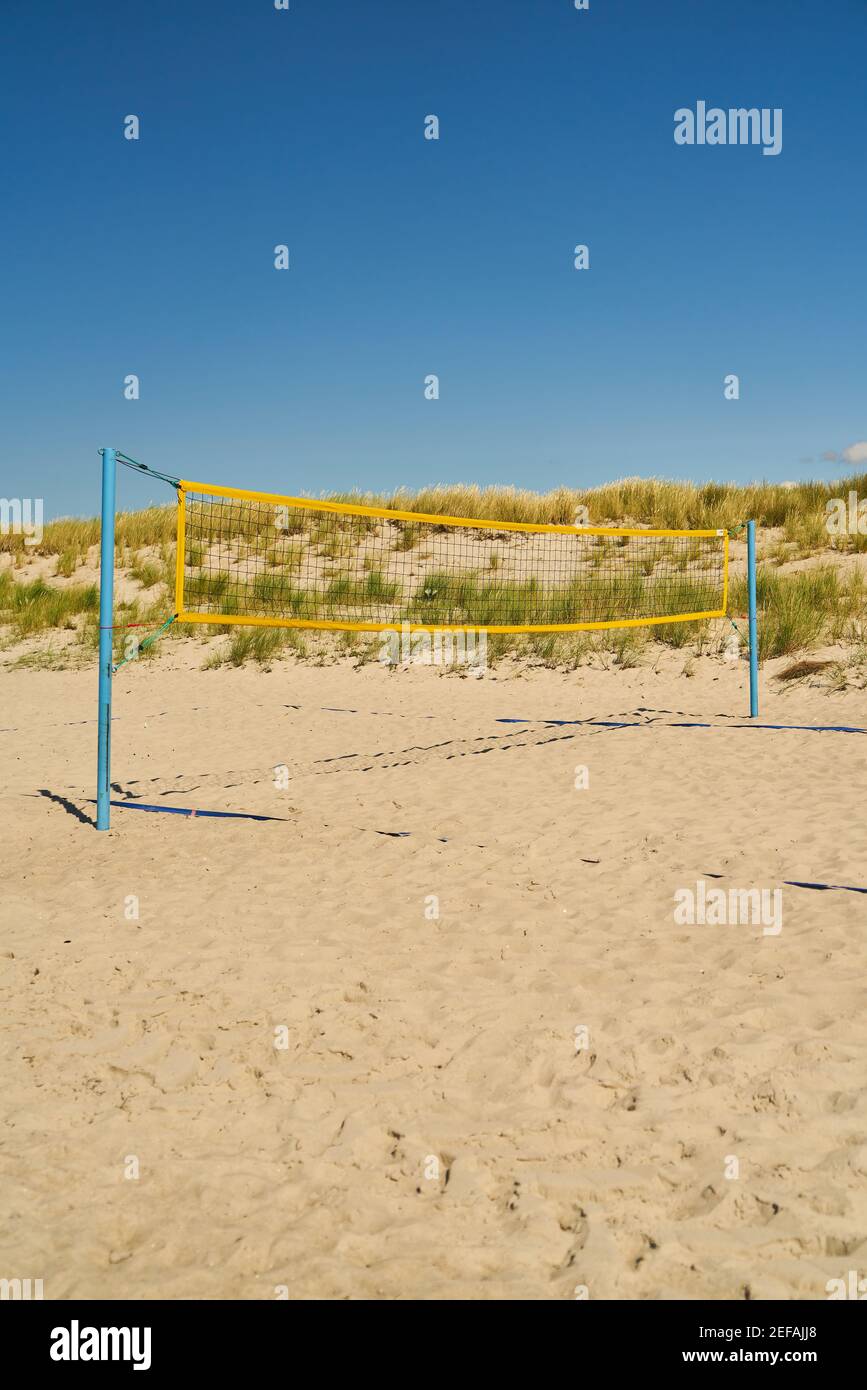 Beach with sand and playing field for beach volleyball against a blue sky Stock Photo
