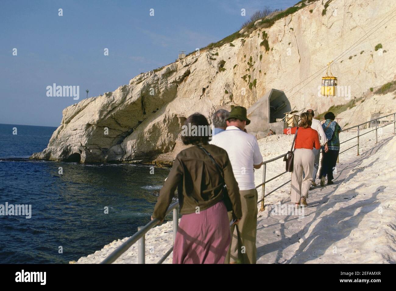 Rear view of a group of tourists walking towards an overhead cable car station, Israel Stock Photo