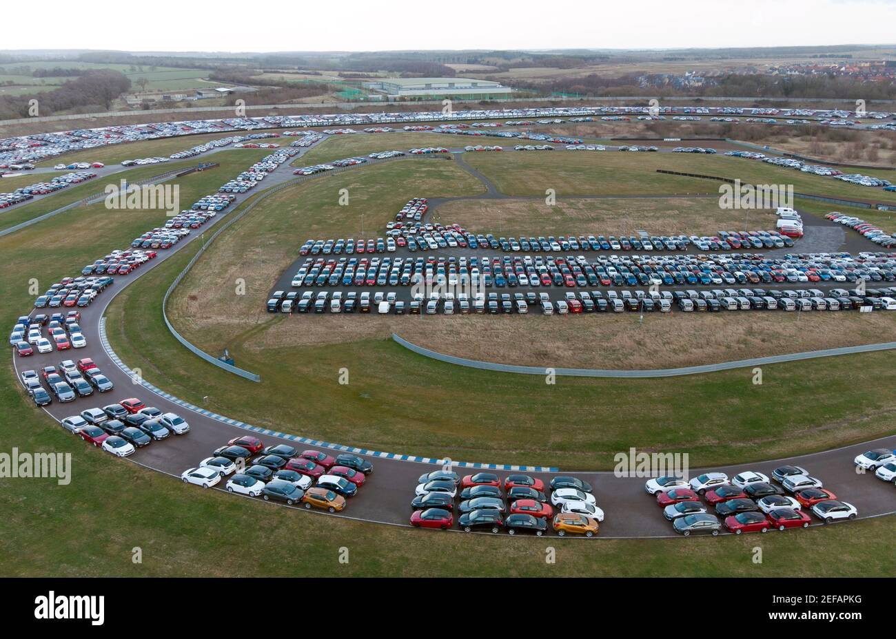 Thousands of cars parked at the Rockingham Logistics Hub in Corby,  Northamptonshire. The 250-acre site was a race track for motorsport events  until it was sold in 2018 and converted into a