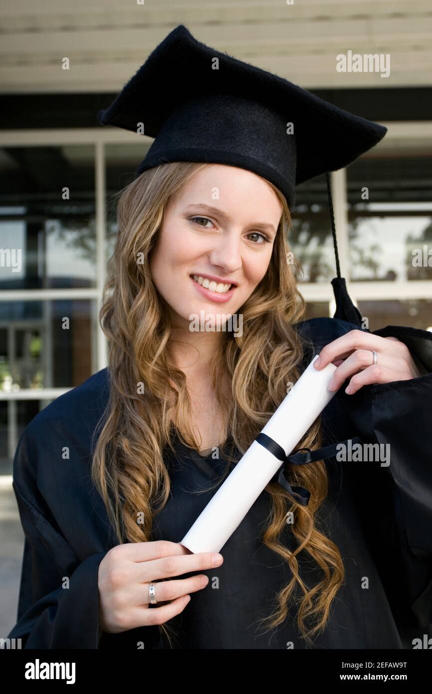 Portrait of a female graduate holding her degree and smiling Stock ...