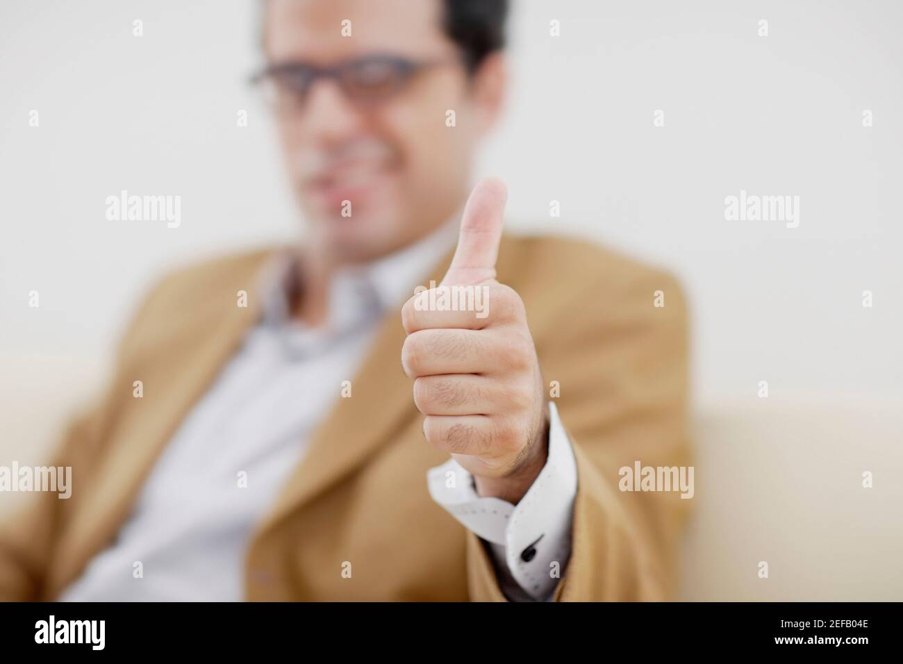 mid adult man giving a thumbs up sign Stock Photo