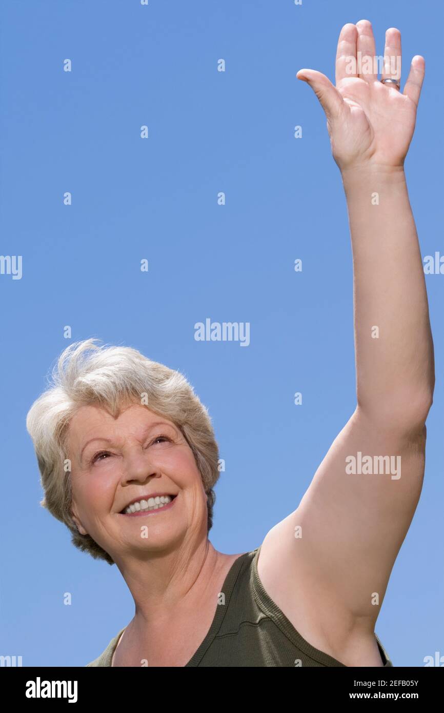 Low angle view of a senior woman waving her hand Stock Photo
