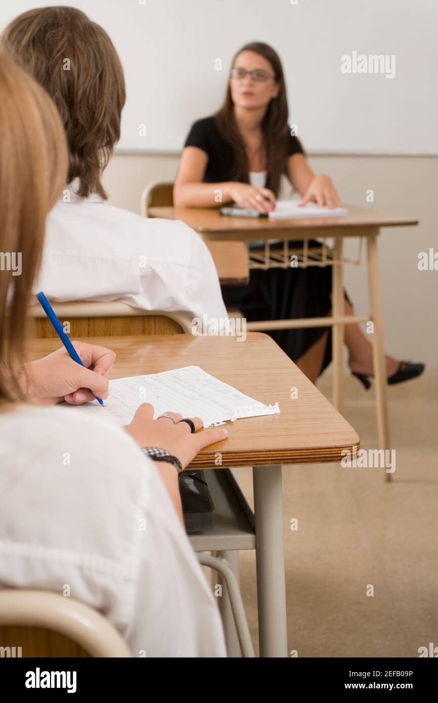 Female teacher with teenage students in the classroom Stock Photo