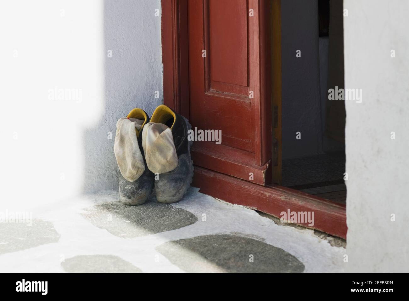 Pair of shoes at a door, Mykonos, Cyclades Islands, Greece Stock Photo