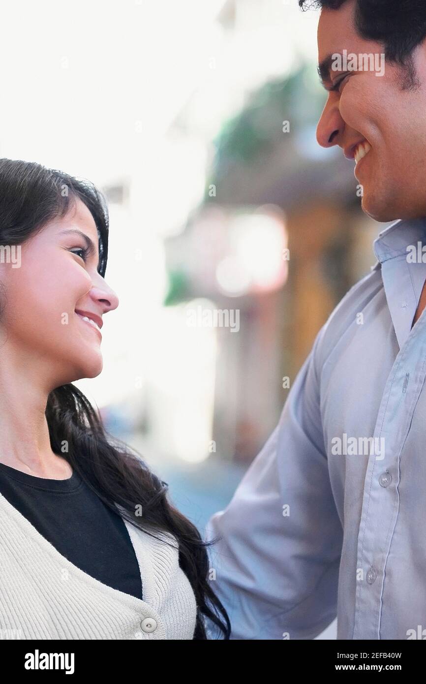 Close up of a young man and a teenage girl looking at each other and ...