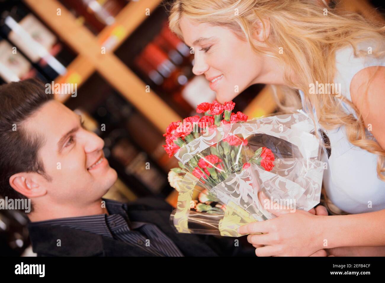 Close up of a young couple holding a bouquet of flowers and smiling Stock Photo