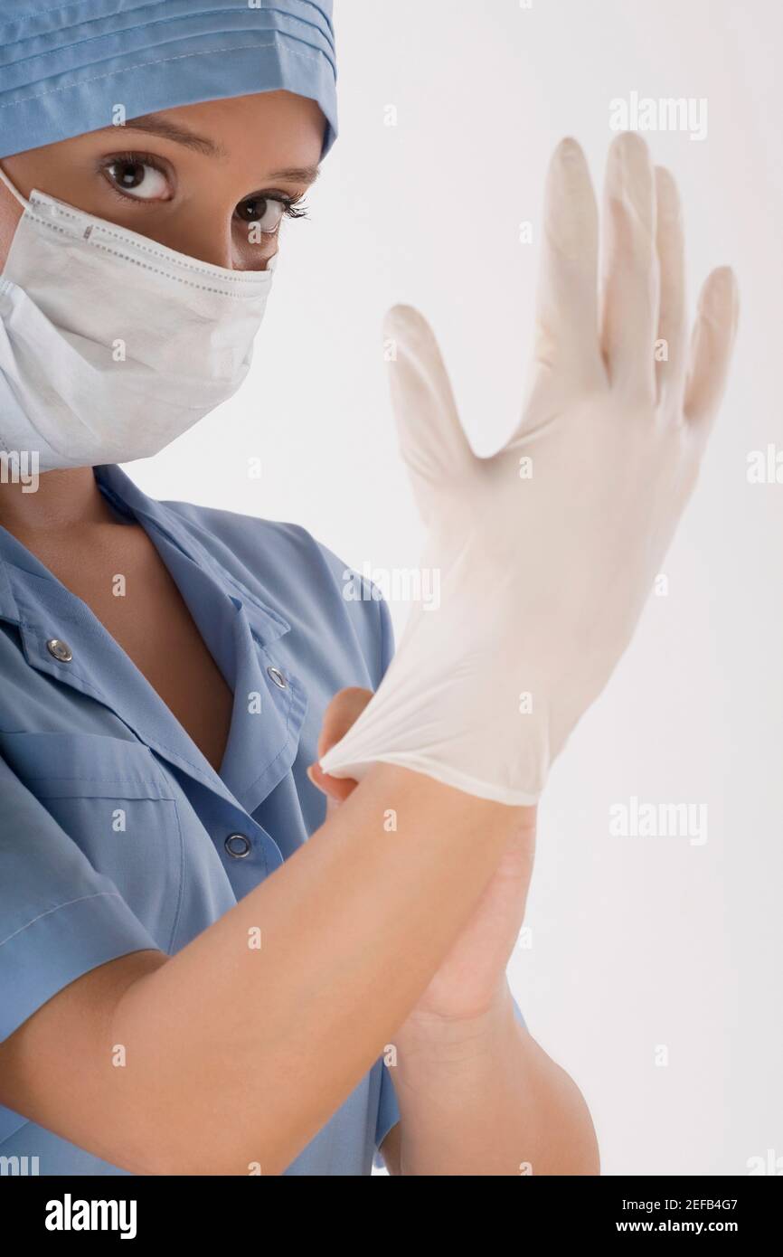 Female surgeon wearing a surgical glove Stock Photo