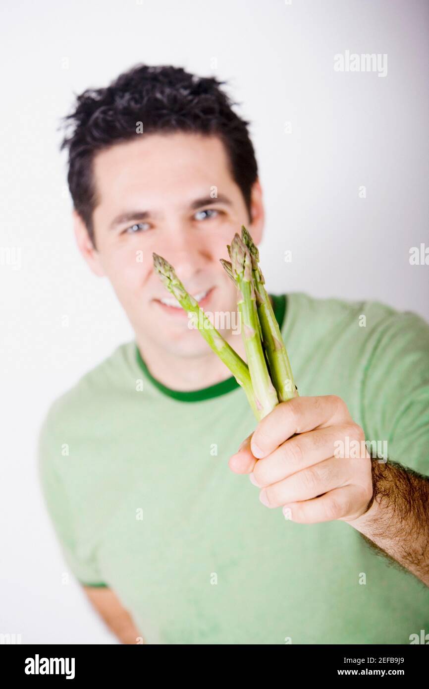 Portrait of a mid adult man holding asparagus and smiling Stock Photo Alamy