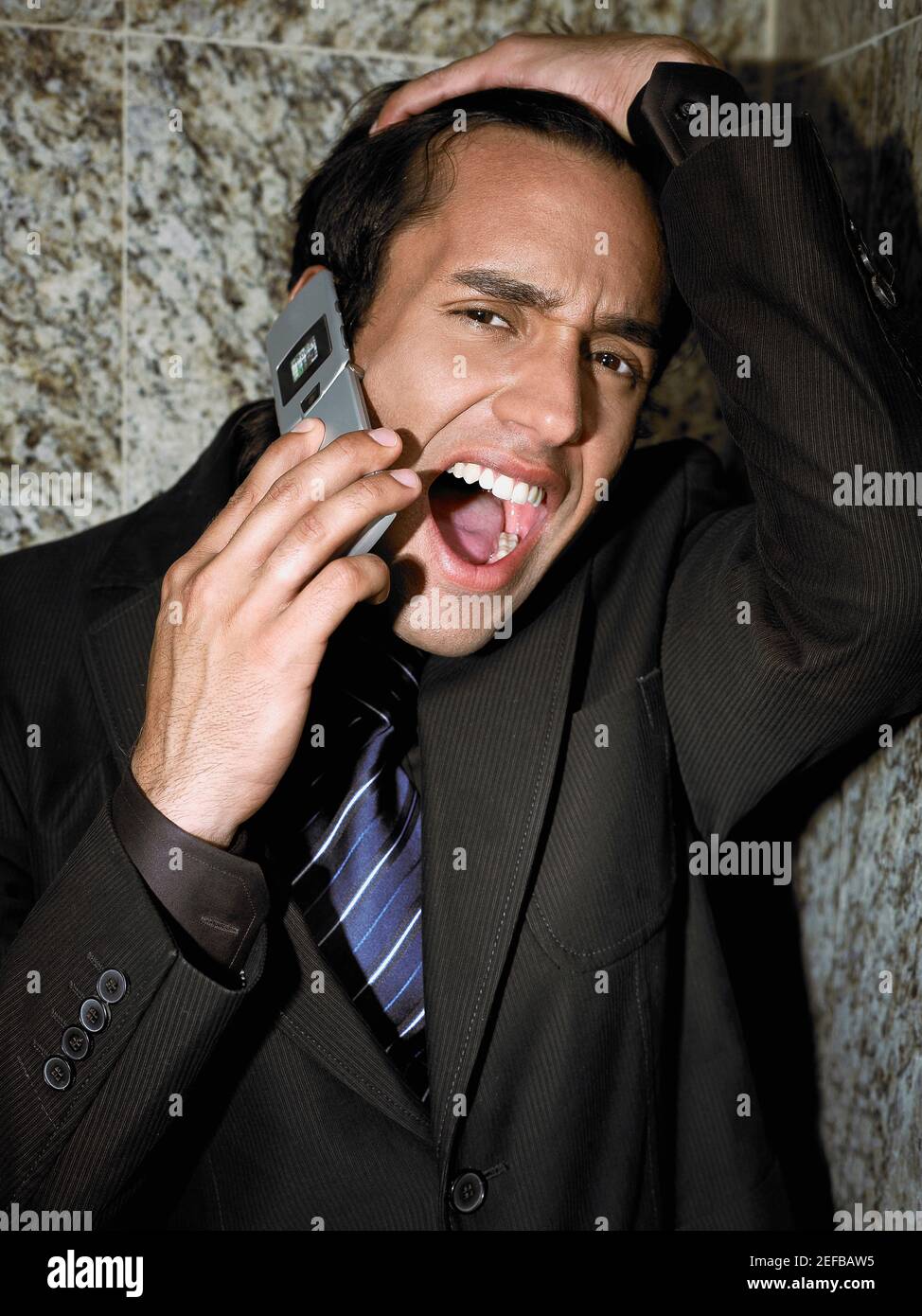 Portrait of a young businessman shouting into a mobile phone Stock Photo