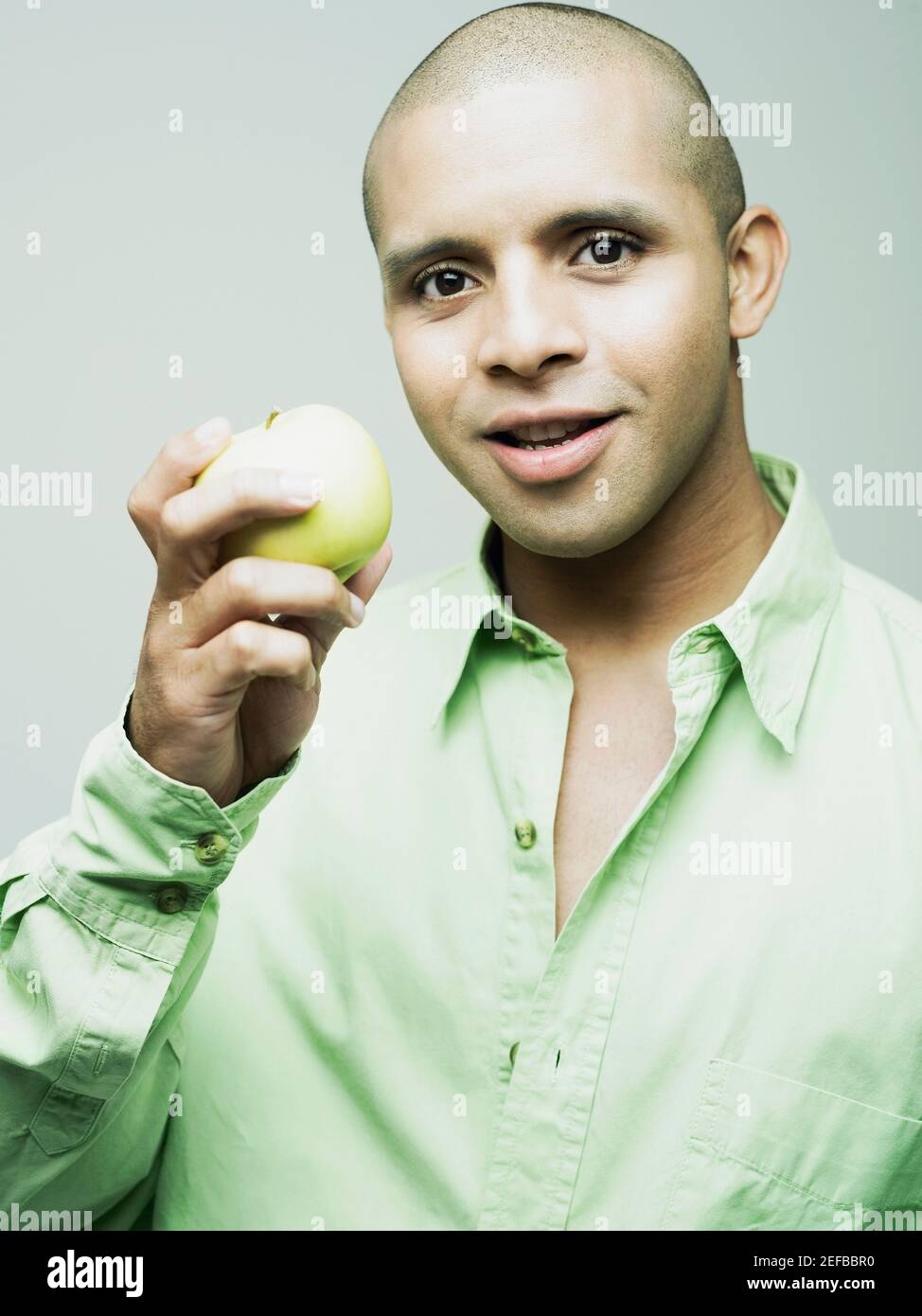 Portrait of a young man holding a green apple Stock Photo - Alamy