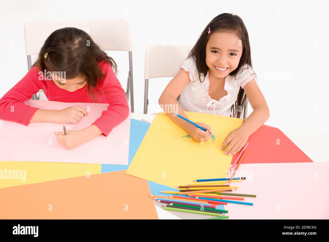High angle view of two girls drawing in a classroom Stock Photo - Alamy