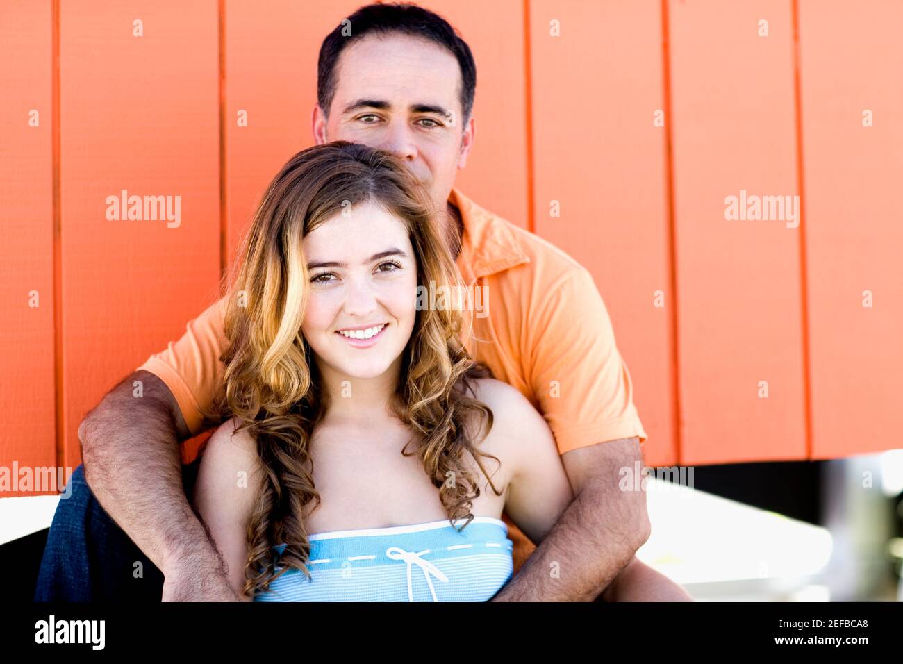 Portrait of a mid adult man embracing a young woman from behind Stock ...