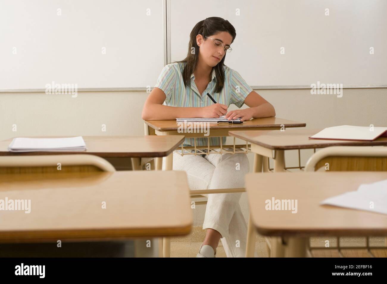 Female teacher writing in a classroom Stock Photo