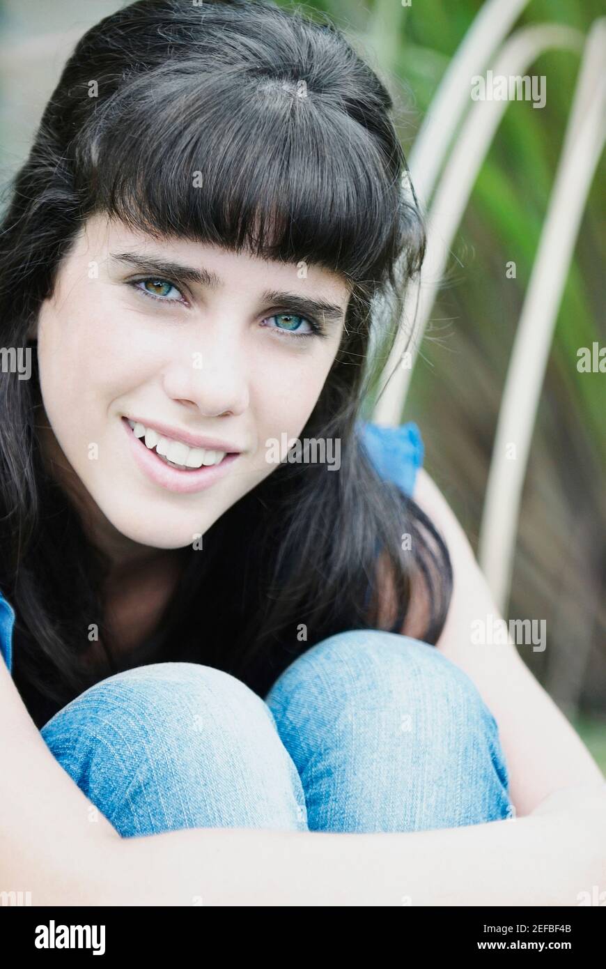 Portrait of a teenage girl hugging her knees and smiling Stock Photo ...