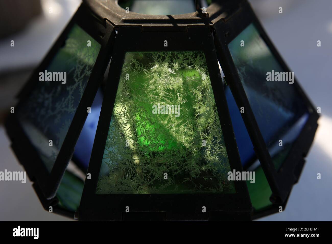 Closeup of a colorful glass lantern with a frost pattern under the ...