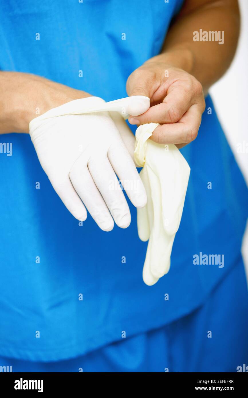 Closeup of a male surgeonÅ½s hand removing a surgical glove from his