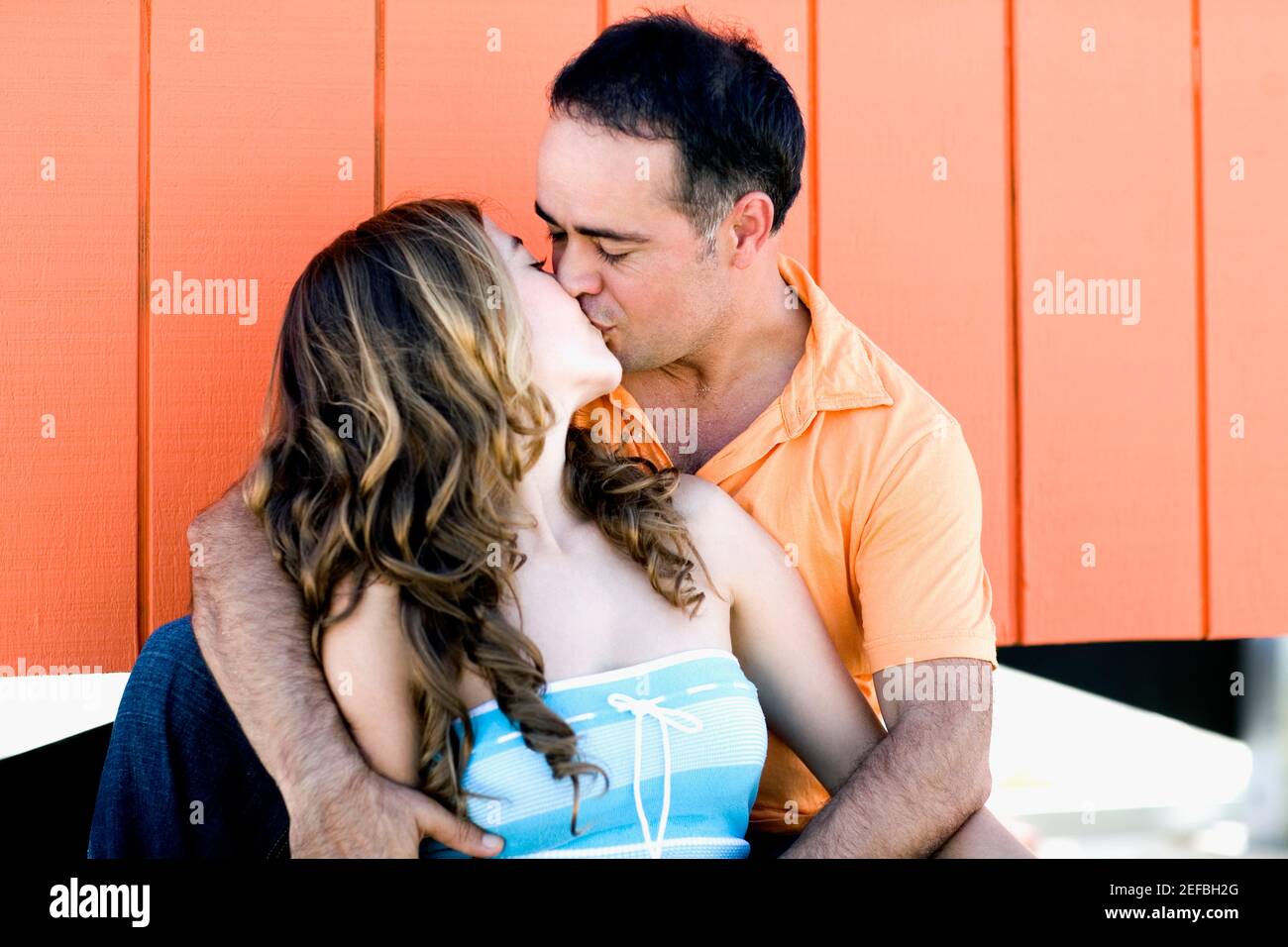 Mid adult man and a young woman kissing each other Stock Photo - Alamy