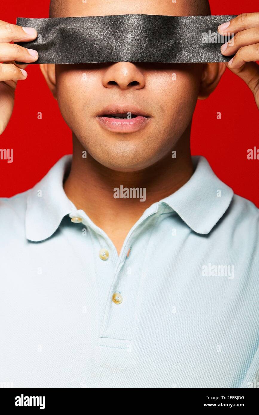 Close up of a young man holding duct tape in front of his eyes Stock Photo Alamy