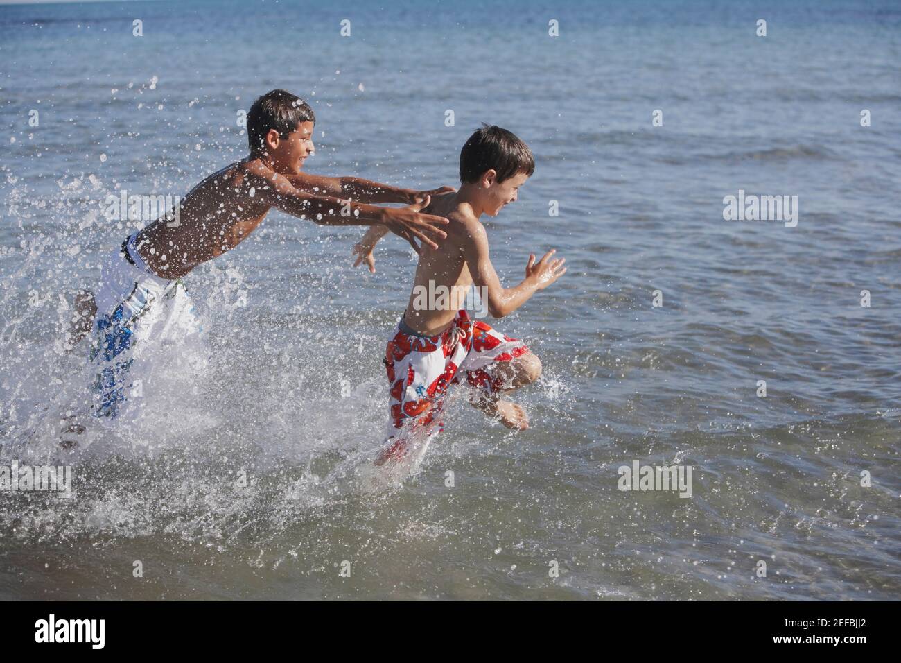 Teenage boy and a boy playing in the sea Stock Photo - Alamy