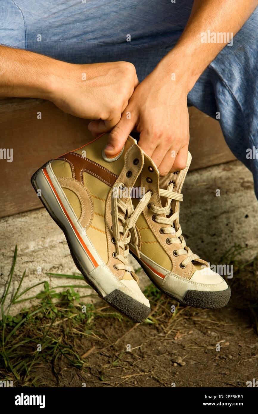 Close-up of a personÅ½s hand holding a pair of canvas shoe Stock Photo