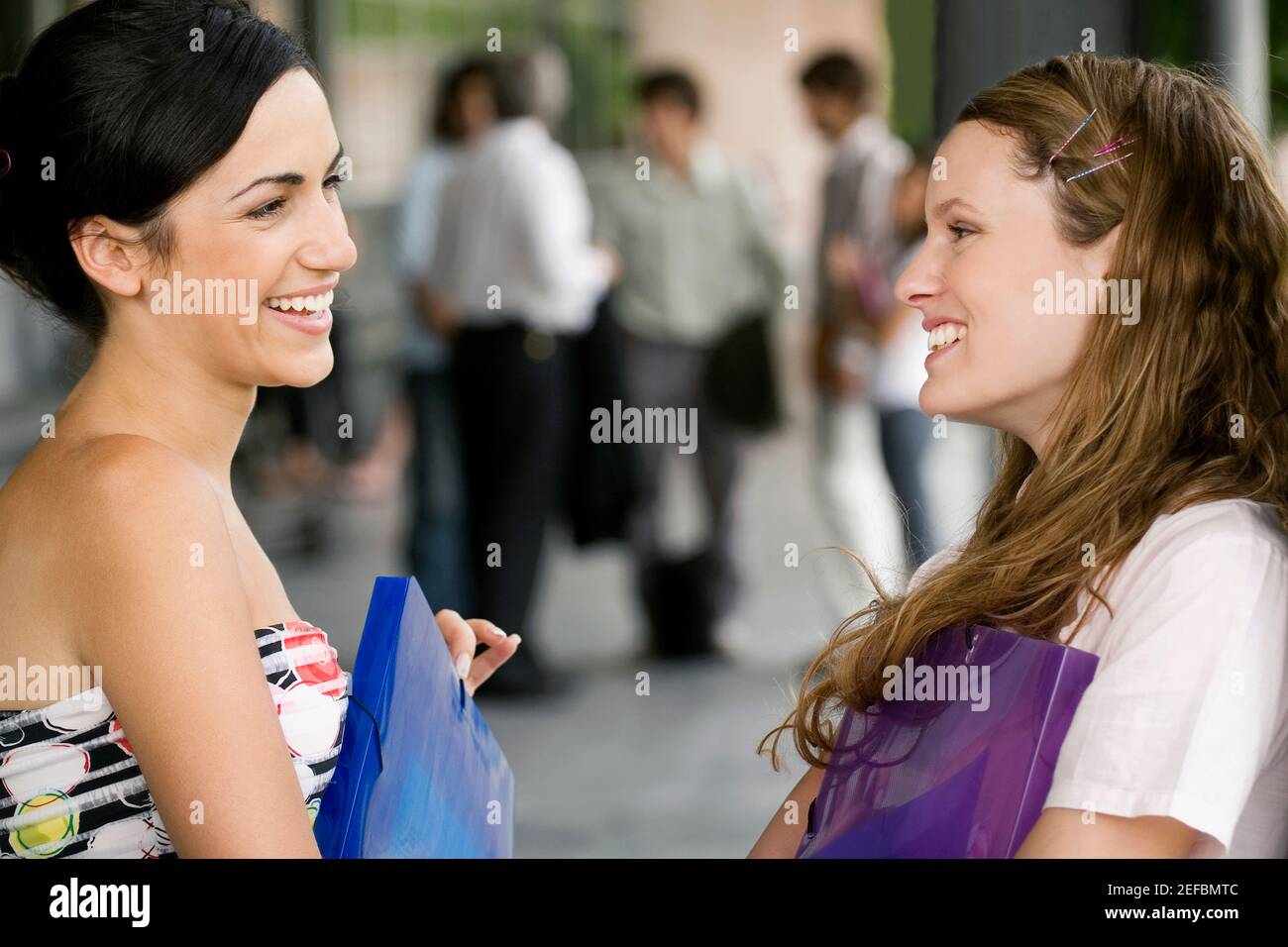 Close up of two young women looking at each other and smiling Stock ...