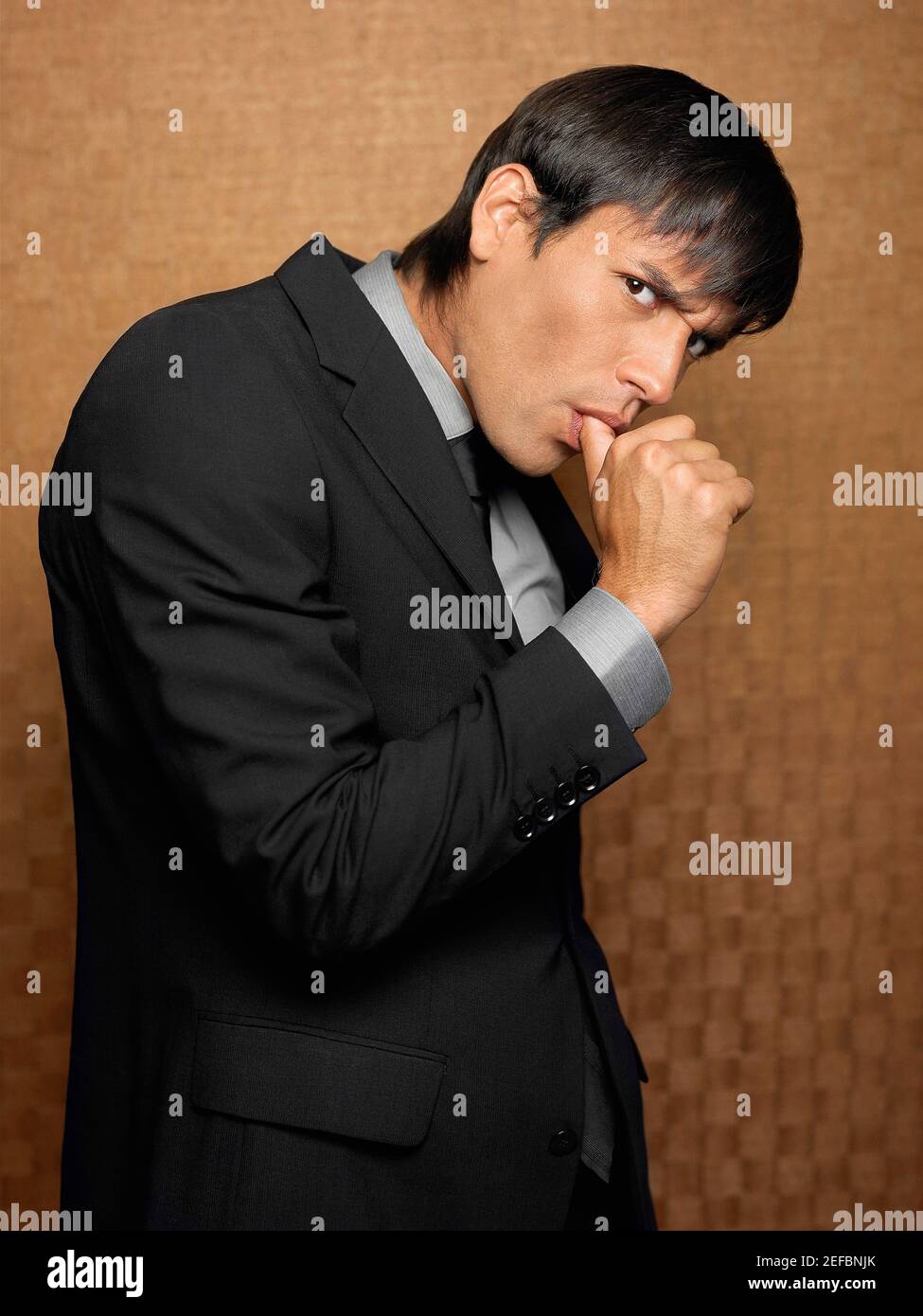 Side profile of a businessman sucking his thumb Stock Photo
