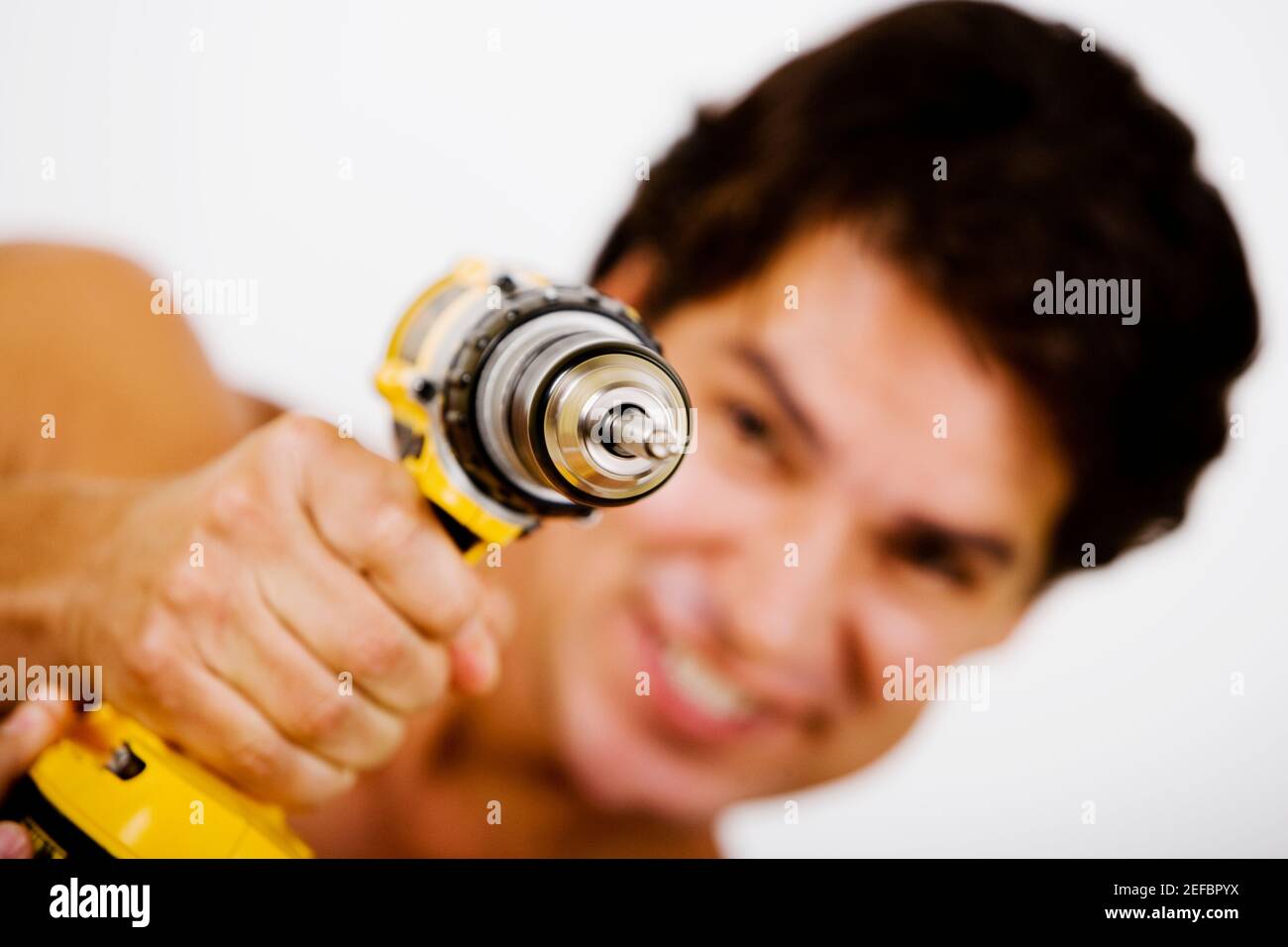 Portrait of a mid adult man holding a drill machine Stock Photo