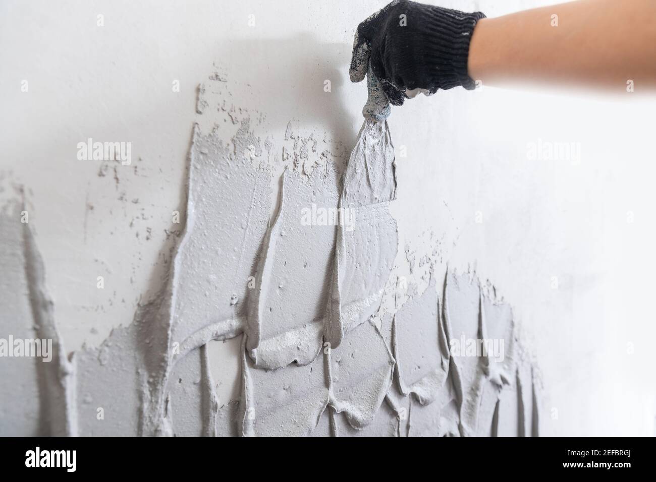 Plaster mortar for gray concrete wall on trowel. Stock Photo
