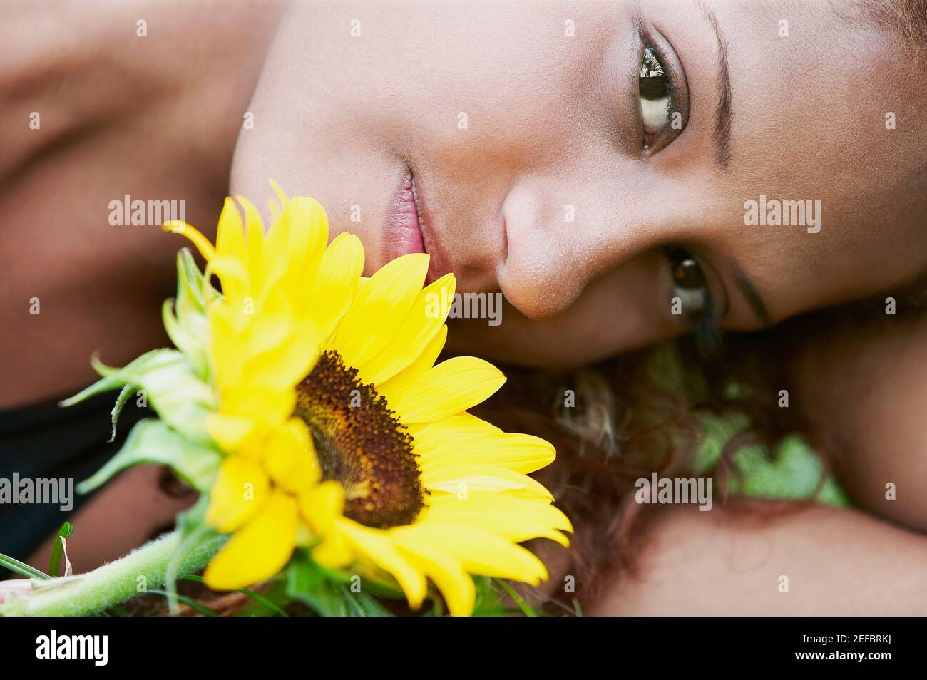 Portrait of a young woman with a sunflower Stock Photo - Alamy