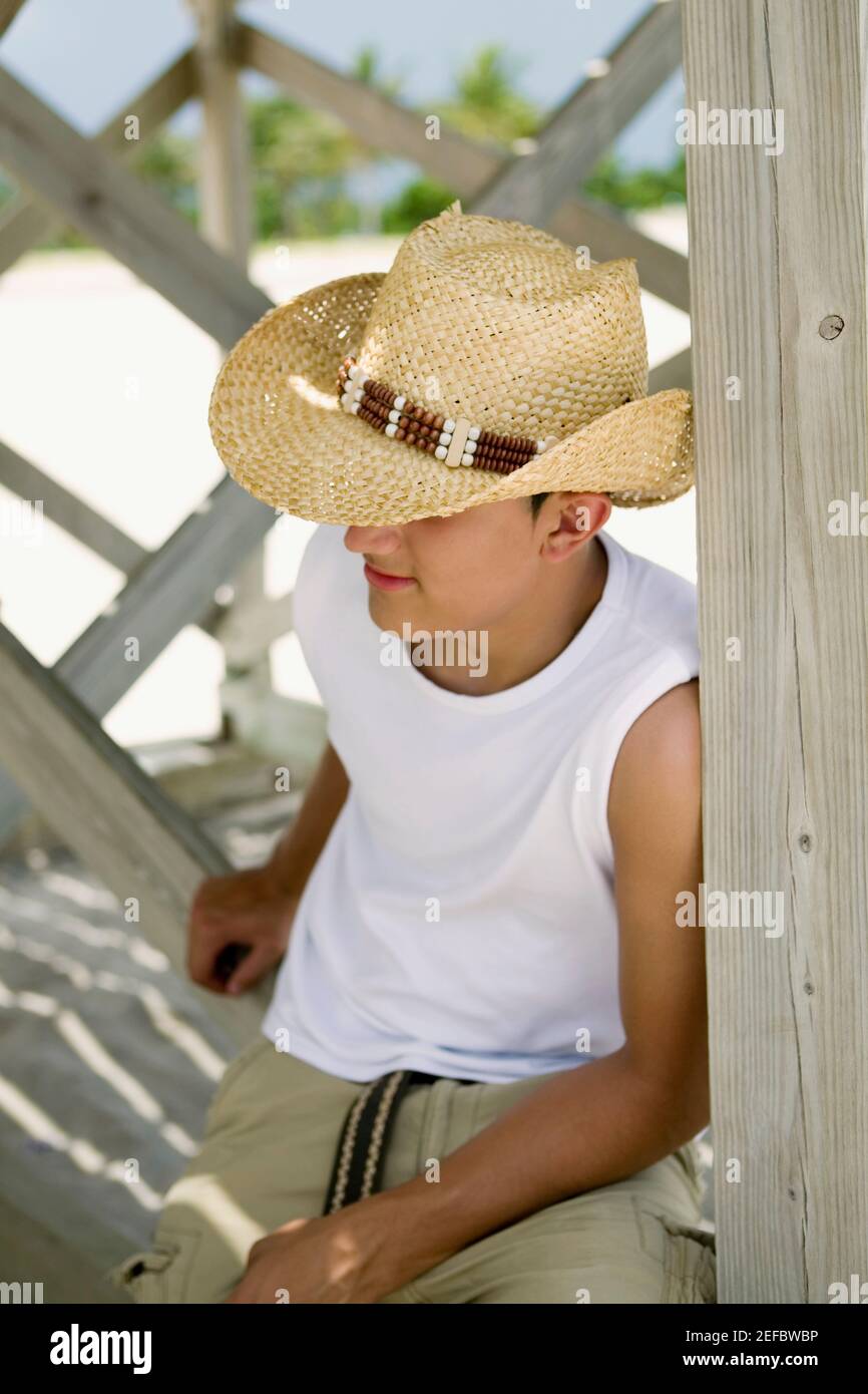 Close-up of a teenage boy wearing a straw hat Stock Photo