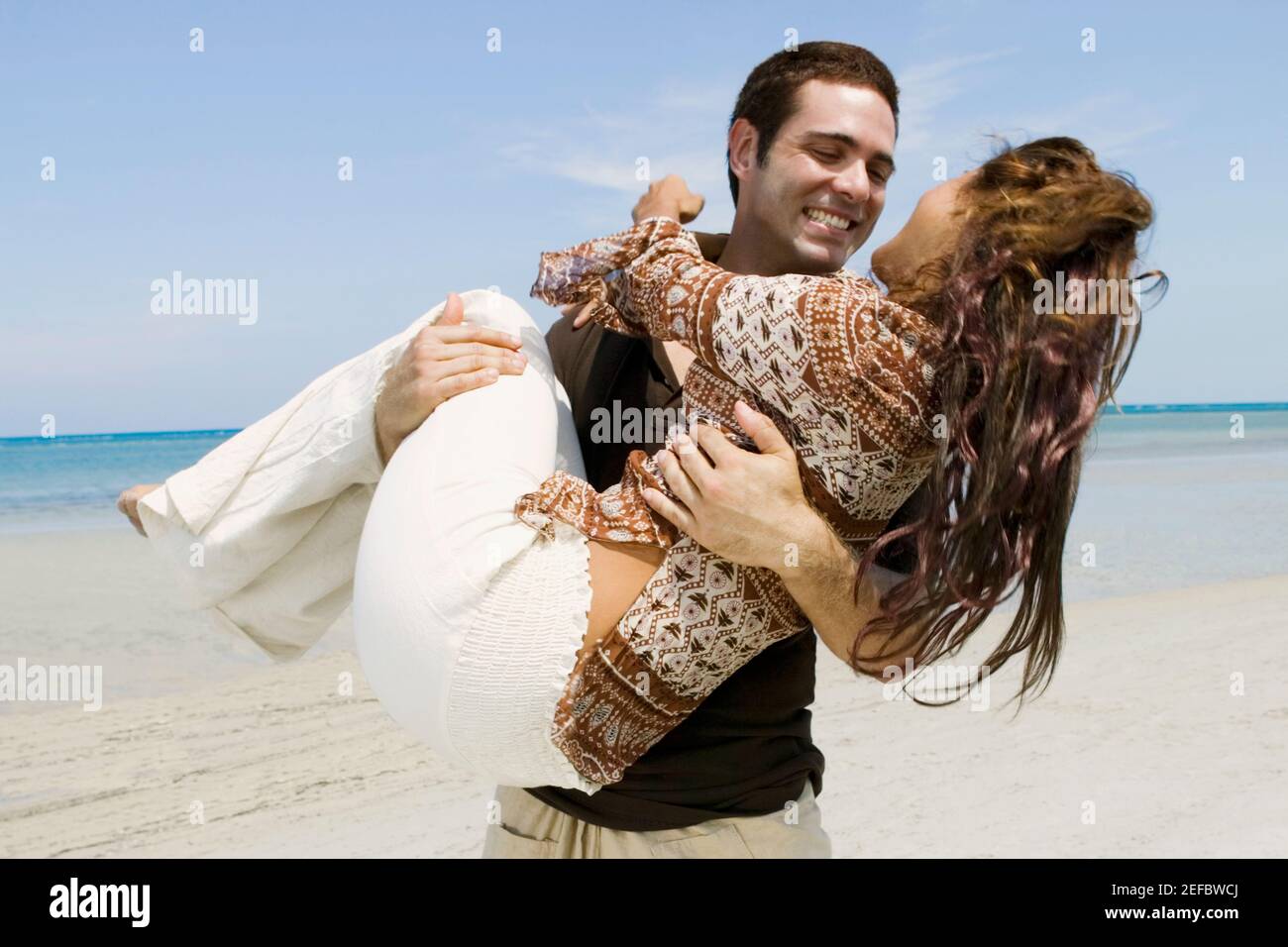 Man carrying a woman in the sea hi-res stock photography and images - Alamy