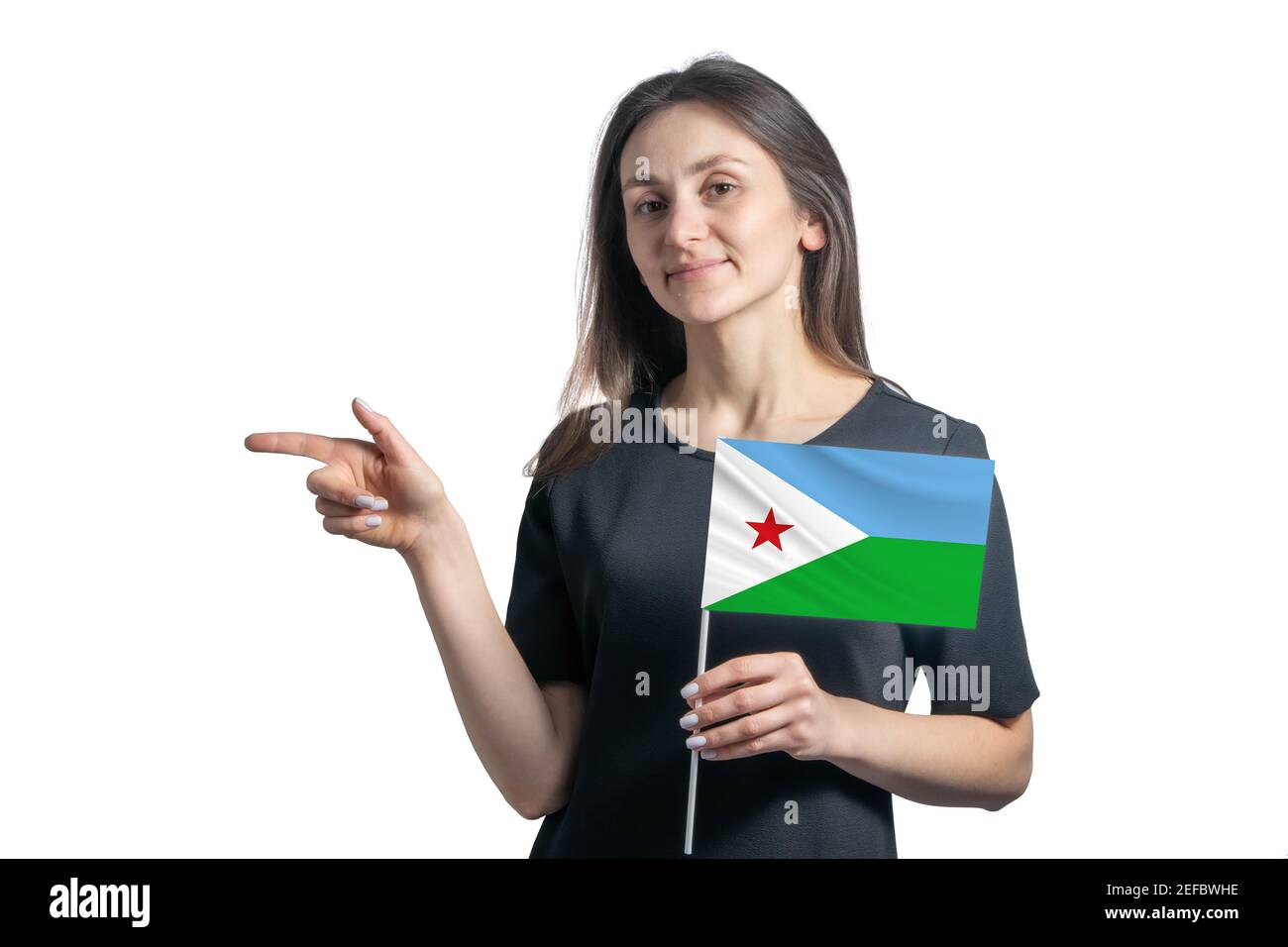 Happy young white woman holding flag Djibouti and points to the left isolated on a white background. Stock Photo