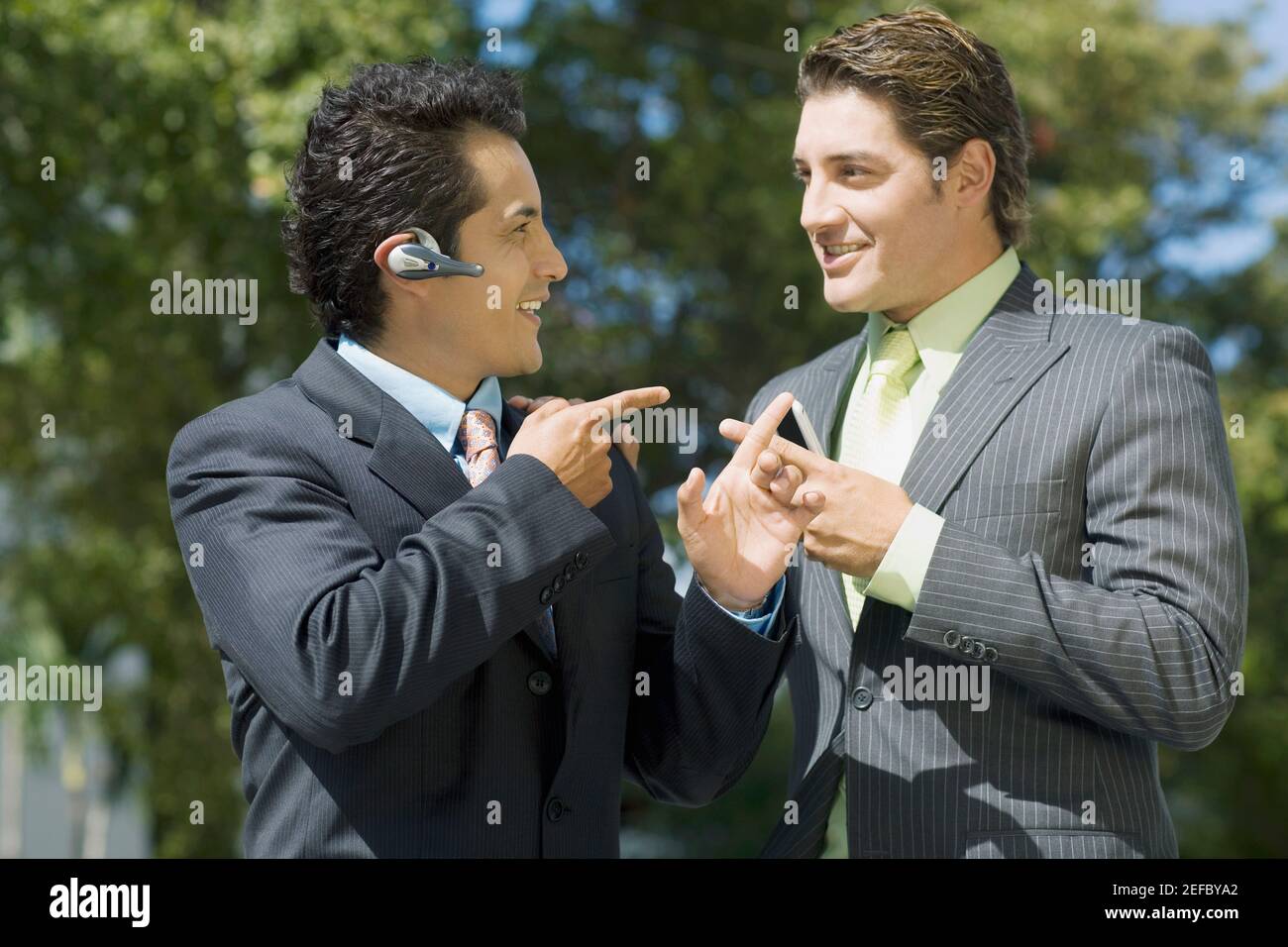 Two businessmen looking at each other and smiling Stock Photo - Alamy