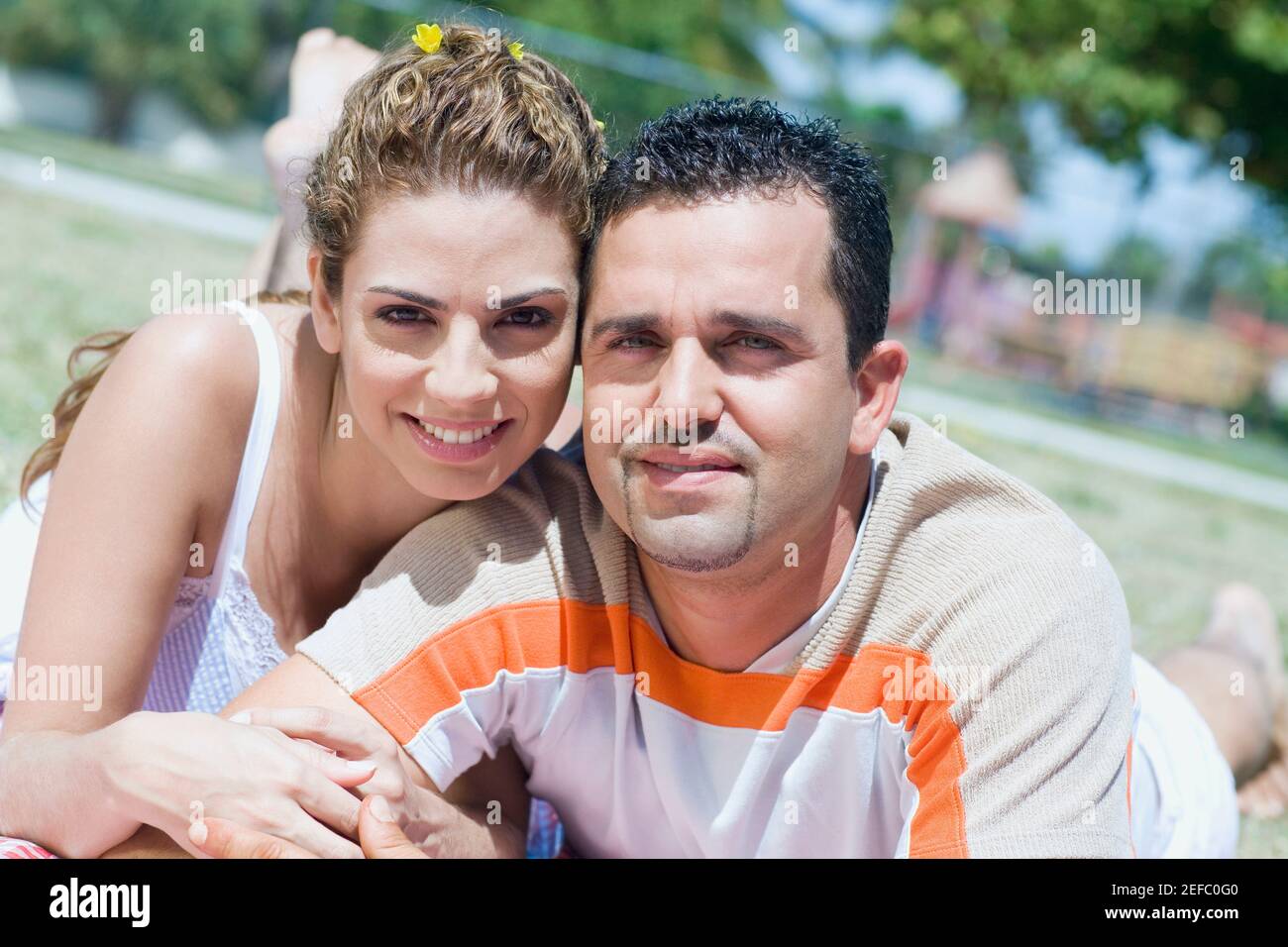 Portrait of a mid adult couple lying in a lawn Stock Photo - Alamy