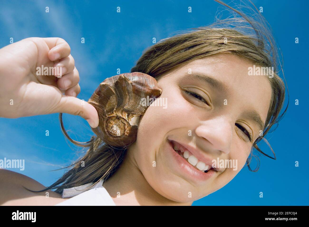Conch shell listening hi-res stock photography and images - Alamy