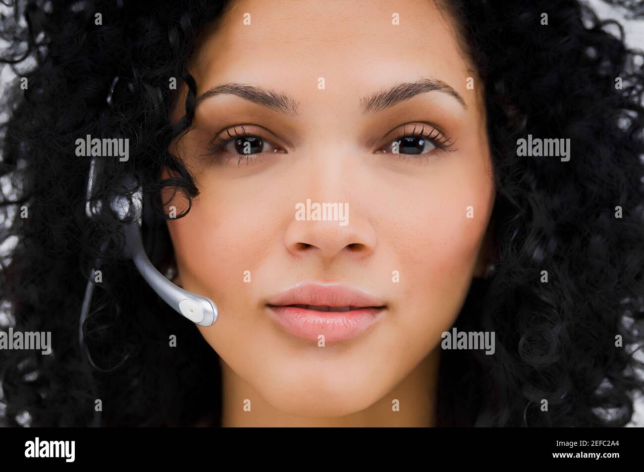 Portrait of a female customer service representative wearing a headset ...