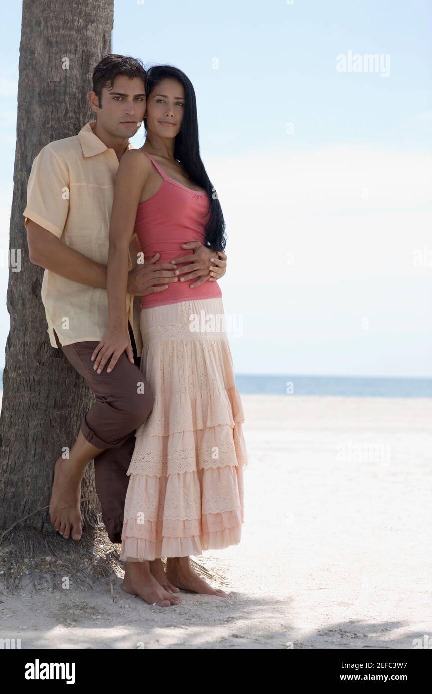 Portrait of a young man embracing a young woman on the beach Stock ...