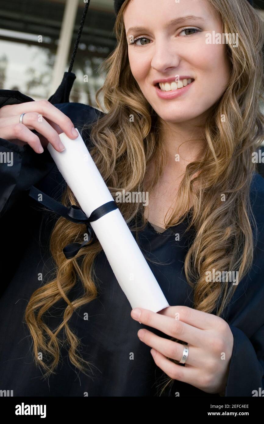 Portrait of a female graduate holding her degree Stock Photo - Alamy