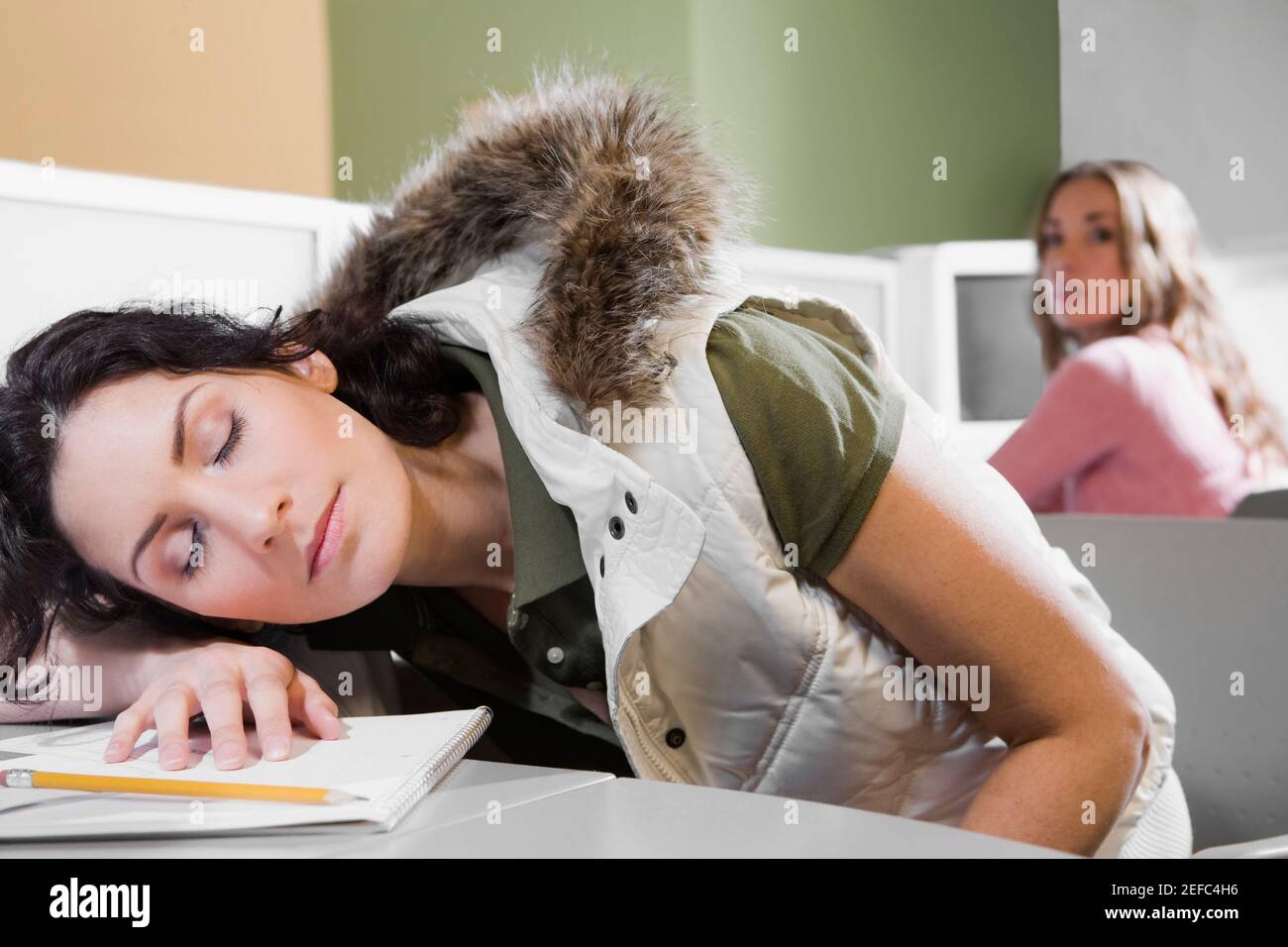 Young woman napping on a desk Stock Photo - Alamy