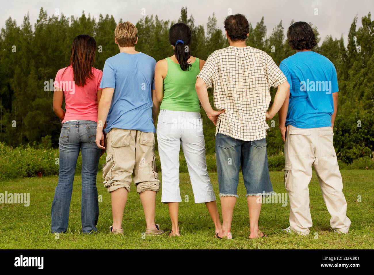 Rear view of five people standing side by side Stock Photo