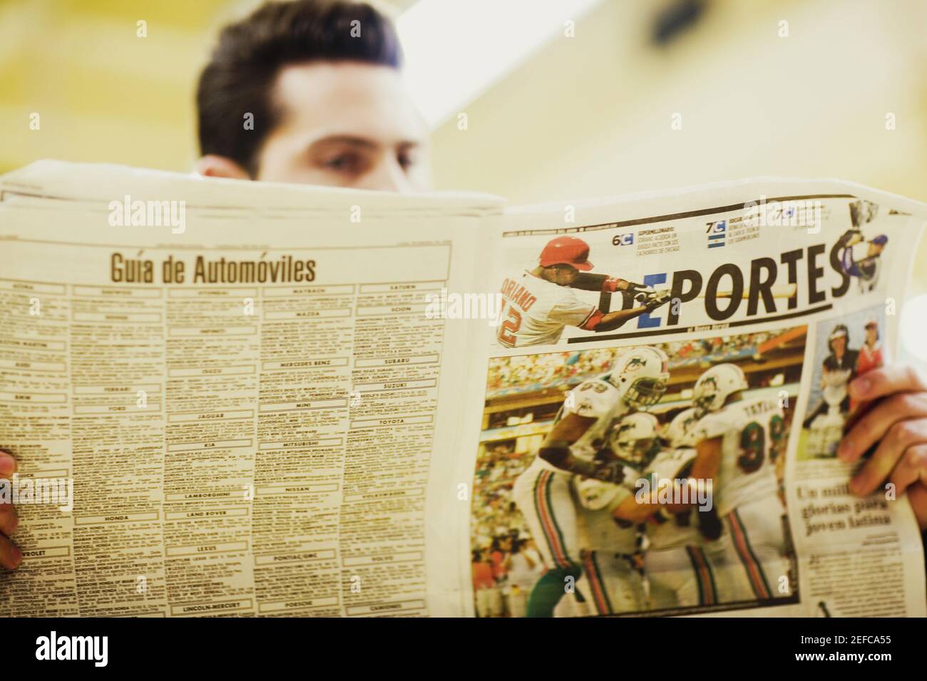 Close up of a young man reading a newspaper Stock Photo - Alamy