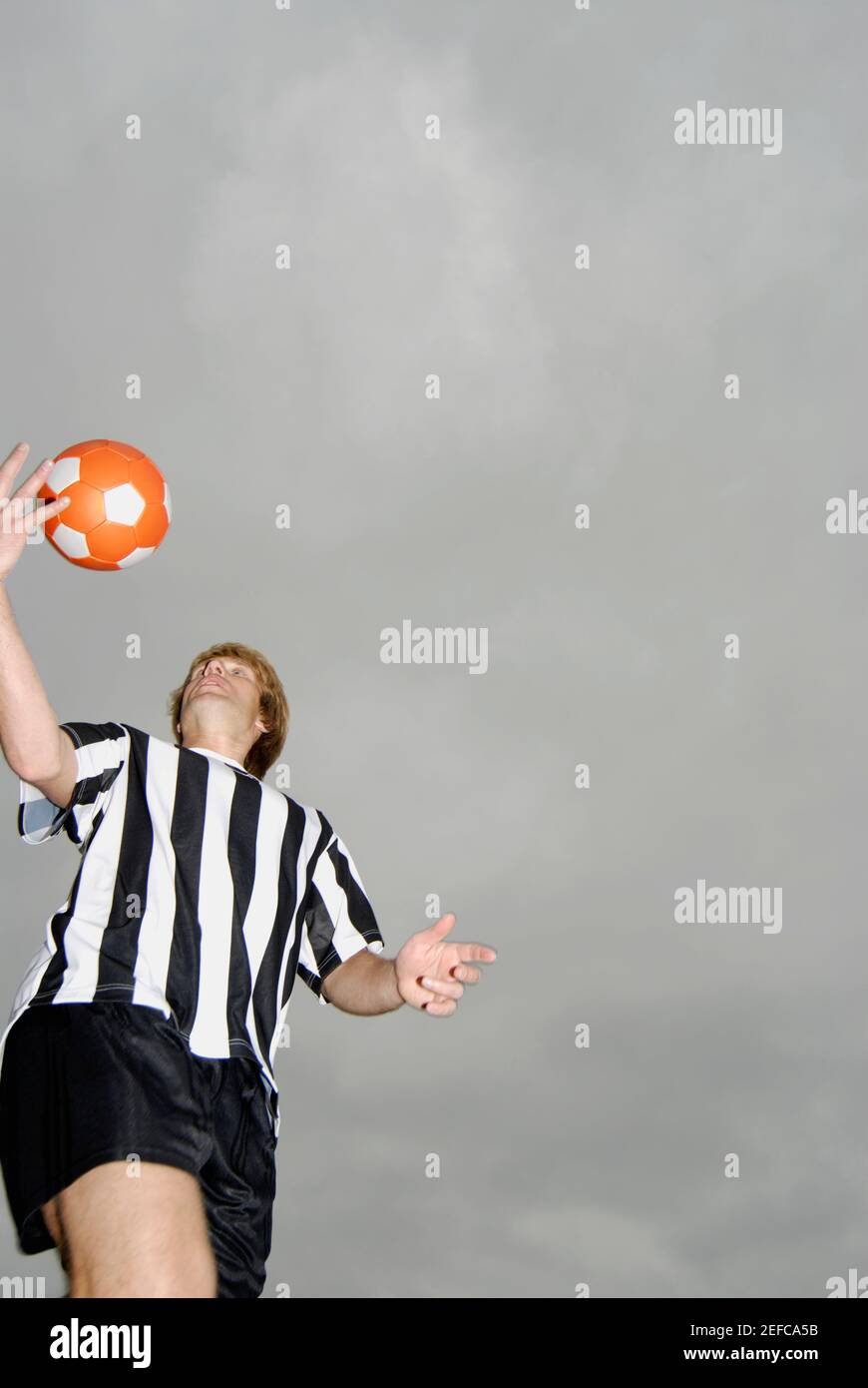 Low angle view of a soccer player tossing a soccer ball Stock Photo