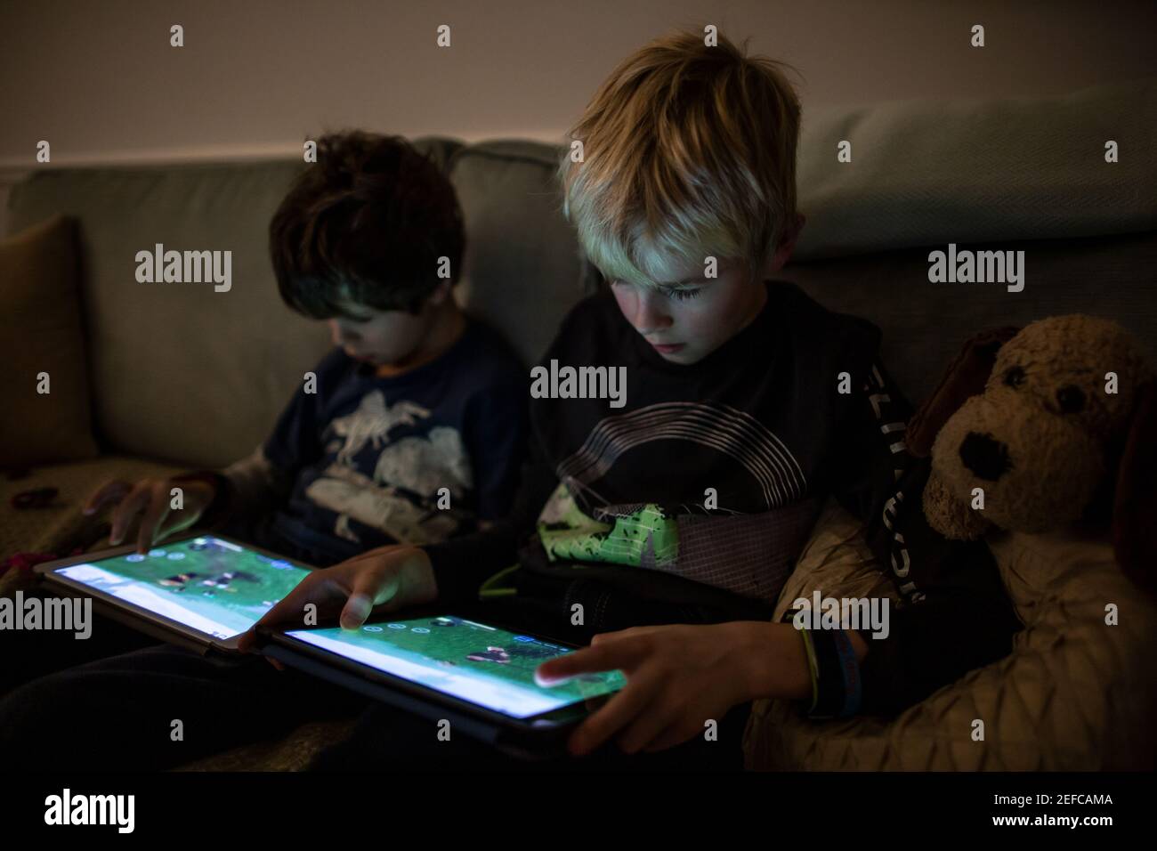 Boys playing 'Roblox' on their iPad tablets at home during school closure due to the coronavirus lockdown restrictions, England, United Kingdom Stock Photo